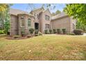Charming brick home featuring manicured lawn, a fountain, and mature landscaping at 472 Barber Loop, Mooresville, NC 28117