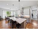 Bright, open kitchen with large island, stainless steel hood vent, and adjoining dining area with natural light at 5941 Legacy Ln, Kannapolis, NC 28081