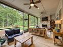Relaxing screened-in porch with a cozy brick fireplace and comfortable seating overlooking the backyard at 5941 Legacy Ln, Kannapolis, NC 28081