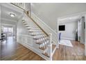 Elegant staircase featuring white railings, wood treads, and detailed wainscoting at 726 Amberly Xing, Fort Mill, SC 29708