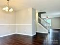 Spacious living room featuring a chandelier, hardwood floors, and a staircase to the upper level at 7306 Fox Point Dr, Charlotte, NC 28269