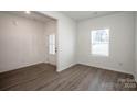 Spacious living room with wood-look floors, a large window, and an entry door at 955 General Hoke Dr, Lincolnton, NC 28092