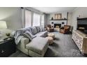 The inviting living room features neutral decor, fireplace, and a view to the backyard at 1007 Little John Trl, Kannapolis, NC 28081