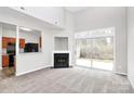 Bright open living room with a fireplace, access to a patio, and an open view to the kitchen at 1765 Holliford Ct, Charlotte, NC 28215