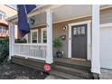 Inviting front porch with white railings, a hanging plant, and a decorative flag at 1921 Kenilworth Ave, Charlotte, NC 28203