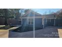 Rear exterior featuring a blue home with a well kept yard with new mulch and a paved patio area at 2721 Dora Dr, Charlotte, NC 28215
