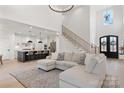 Bright, open-concept living room featuring a large sofa, a staircase, and a view into a modern kitchen at 296 Riley Dr, Taylorsville, NC 28681