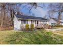 Charming single-story home featuring a wooden porch, dark shutters, and a neatly maintained lawn at 2992 Greenleaf Rd, Clover, SC 29710