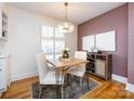 Dining room with hardwood floors, exposed brick, and a modern light fixture at 4310 Randolph Rd, Charlotte, NC 28211