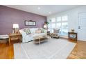 Cozy living room featuring a decorative brick wall, hardwood floors, and large bright windows at 4310 Randolph Rd, Charlotte, NC 28211