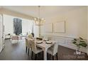 Formal dining room features a large bay window, modern chandelier, and direct access to the living spaces at 5225 Lila Wood Cir, Charlotte, NC 28209