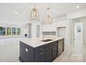 Modern kitchen with a large island, pendant lighting, and stainless steel appliances at 5233 Glenwalk Dr # 0063, Charlotte, NC 28269