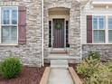 A stone archway frames the front door, adorned with a wreath and potted plants at 7206 Sumters Camp Trl, Fort Mill, SC 29707