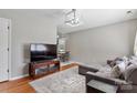 Inviting living room featuring hardwood floors, a comfortable gray sofa, and modern lighting at 909 Laye St, Belmont, NC 28012