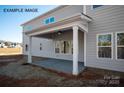 Covered back patio with white columns, fan, and concrete base offers a great entertaining space at 11016 Tyler Brook Ln # Oak0036, Mint Hill, NC 28227