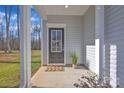 Welcoming front porch featuring a stylish black front door with glass panes and neutral siding at 120 Orville Rd, Statesville, NC 28677