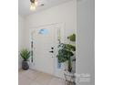 Bright foyer with a white front door with sidelights and tile flooring at 15314 Logan Grove Rd, Charlotte, NC 28227