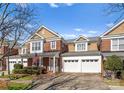 Charming brick townhome with an American flag on the front porch and a spacious two-car garage at 18409 Harborside Dr, Cornelius, NC 28031