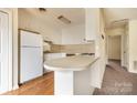 Efficient kitchen with white cabinetry, laminate countertops, and a breakfast bar overlooking the living room at 281 S Herlong Ave # Apt E, Rock Hill, SC 29732