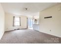 Spacious living room with neutral carpet, sliding glass doors to patio, and a breakfast bar to the kitchen at 281 S Herlong Ave # Apt E, Rock Hill, SC 29732