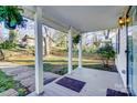 Charming covered front porch with hanging plants and views of the yard and picket fence at 305 S Clay St, Gastonia, NC 28052