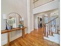 Inviting foyer with hardwood floors, staircase, high ceilings, and a decorative mirror on a wood table at 411 Belo Ct, Fort Mill, SC 29715