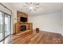 Spacious living room features wood floors, stone fireplace, and a sliding glass door at 5011 Sharon Rd # B, Charlotte, NC 28210