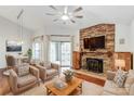 Cozy living room boasts a stone fireplace, ceiling fan, and sliding door to the balcony at 5011 Sharon Rd # B, Charlotte, NC 28210