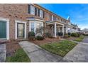 Brick townhomes showcasing classic architectural details, well-maintained landscaping, and a welcoming neighborhood setting at 5472 Ives Nw St, Concord, NC 28027