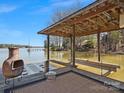 Covered boat dock with a cozy seating area, providing direct access to the serene waters for boating and relaxation at 5981 Johnson Rd, Lake Wylie, SC 29710
