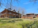 Spacious log home featuring stone accents, multiple balconies, and lush lawn with mature landscaping at 5981 Johnson Rd, Lake Wylie, SC 29710