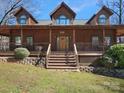 Charming log home featuring a welcoming front porch with wooden railings and a beautifully landscaped yard at 5981 Johnson Rd, Lake Wylie, SC 29710