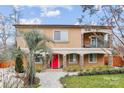 Inviting two-story home featuring a bright red door, lush landscaping, and a charming second-story balcony at 8104 Stem Ct, Charlotte, NC 28227