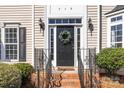Inviting front door with sidelights, black hardware, and a decorative wreath at 910 Elrond Nw Dr, Charlotte, NC 28269