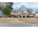 Well-maintained brick home featuring red shutters, a carport, and mature landscaping at 1018 Eaglewood Ave, Charlotte, NC 28212