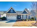 Charming single-Gathering home with stone accents, two-car garage, and landscaped front yard at 1024 Mayapple Way, Belmont, NC 28012