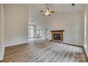 Spacious living room with a charming fireplace, ceiling fan, and new flooring at 106 Aurora Ln # 31, Huntersville, NC 28078