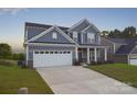 Inviting two-story home with a large garage, well-manicured lawn and sidewalk at 111 Megby Trl, Statesville, NC 28677