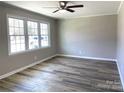 Bright living room with large windows, ceiling fan, and modern laminate wood flooring at 1141 Faile St, Lancaster, SC 29720