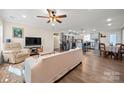 Bright, open-concept living room flowing into a modern kitchen, featuring wood floors and neutral tones at 131 Lowry Row # 8, York, SC 29745