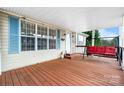 Cozy, covered porch area, featuring a wooden deck and comfortable porch swing at 1818 Valley Springs Se Dr, Conover, NC 28613