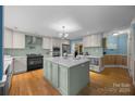 Well-lit kitchen with a center island, stainless steel appliances, and hardwood flooring at 305 Wagner St, Troutman, NC 28166