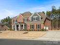 Traditional brick home featuring a manicured lawn, attached garage, and classic architectural details at 3078 Montreaux Valley Dr, Fort Mill, SC 29707