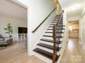 Staircase with dark wood treads and decorative wrought iron railing at 3170 Heathstead Pl, Charlotte, NC 28210