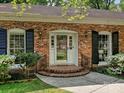 Close-up of the front entrance showcasing brick steps and a glass front door with black window shutters at 4132 Sulkirk Rd, Charlotte, NC 28210