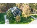Stunning aerial view of a brick home surrounded by lush trees, with impeccable landscaping and a large private lot at 4268 Rustling Woods Dr, Denver, NC 28037