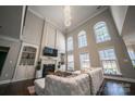 Bright living room with soaring ceilings, fireplace, built-ins, hardwood floors, and large arched windows at 4268 Rustling Woods Dr, Denver, NC 28037