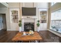 Cozy living room features built-in shelving flanking the fireplace and a large wooden coffee table at 4268 Rustling Woods Dr, Denver, NC 28037