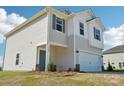 This new construction features a teal entry door, two-car garage, manicured flower beds and a light-colored exterior at 5207 Georgette Trl, Cherryville, NC 28021