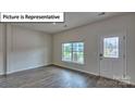 Open-concept living room featuring hardwood floors and a bright window at 7771 Woolsey Dr, Gastonia, NC 28056